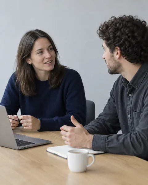 Two colleagues talking through a plan at a table